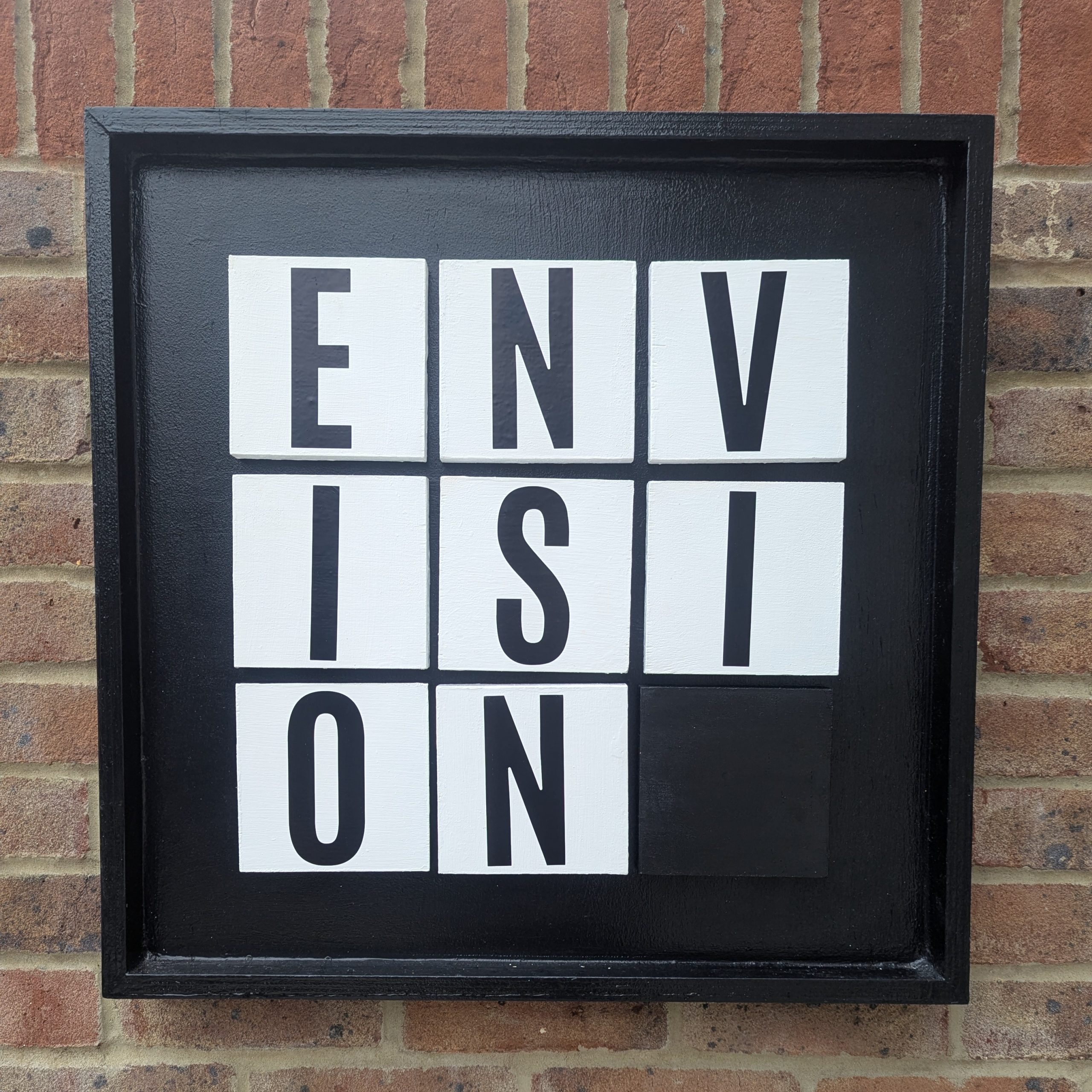 Black vision board with bold black and white lettering applied, showing an optional wordplay theme.